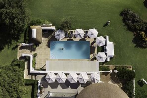 An aerial view of a resort with a swimming pool, sun loungers, and a covered seating area. - Cap Classique Vineyard Pool Suites with Private Pool 1043 (Western Cape)