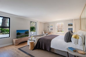 A modern bedroom with a bed, bedside table, and a TV. - Chardonnay Room 1 with Manor Views 1044 (Western Cape)