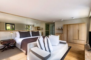 A modern bedroom with a bed, bedside table, lamp, and a large wardrobe. - Chardonnay Room 1 with Manor Views 1044 (Western Cape)