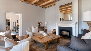 A living room with a fireplace, wooden ceiling beams, a coffee table, and a sofa. - Chardonnay Room 1 with Manor Views 1044 (Western Cape)