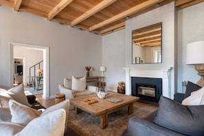 A living room with a fireplace, wooden ceiling beams, a coffee table, and a sofa. - Chardonnay Room 1 with Manor Views 1044 (Western Cape)