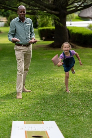 A man and a child playing with a disc golf basket in a grassy area. - Chardonnay Room 1 with Manor Views 1044 (Western Cape)