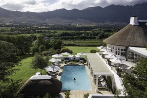 Ein Resort mit Schwimmbad, Liegestühlen und Blick auf die Berge.