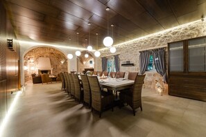 A dining area with a long table, chairs, and hanging lights. - Villa Tihomira - Private villa with pool, Dalmatia (Zaton)