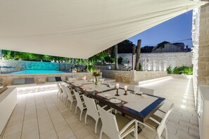 An outdoor dining area with a pool, stone walls, and a covered section. - Villa Tihomira - Private villa with pool, Dalmatia (Zaton)