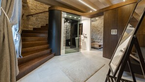 Una escalera conduce a una habitación con paredes de piedra y diseño moderno.