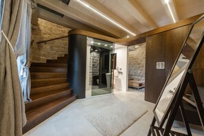 Eine Treppe führt zu einem Raum mit Steinwänden und modernem Design.