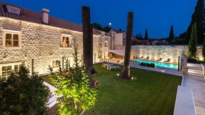 Un edificio de piedra con piscina y zona de estar al aire libre.