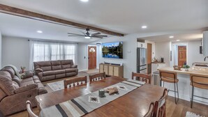A spacious living area with a sofa set, a dining table, and a kitchen area with a refrigerator. - 25 minutes from Clemson, newly remodeled home! (Seneca)