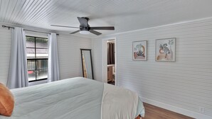 A bedroom with a bed, a ceiling fan, a window with curtains, and two wall-mounted artworks. - 25 minutes from Clemson, newly remodeled home! (Seneca)