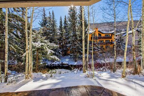 A snow-covered landscape with a yellow building surrounded by trees. - Austria Haus Club 2 bed 2 bath (Vail)