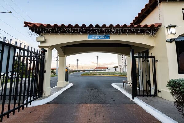 A gated entrance with a sign indicating visitors can enter.
