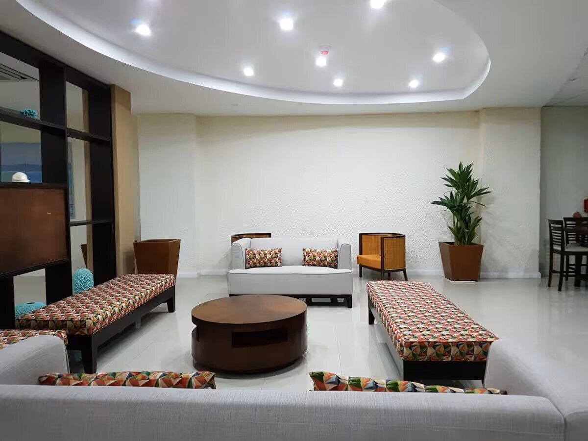 Un salon moderne comprenant un ensemble de canapés, une table basse et un coin repas avec des chaises et une table.