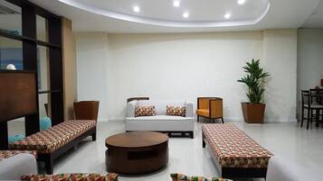 Un salon moderne comprenant un ensemble de canapés, une table basse et un coin repas avec des chaises et une table.