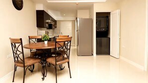 Una cocina moderna con comedor, que incluye una mesa con sillas, un refrigerador y un microondas.