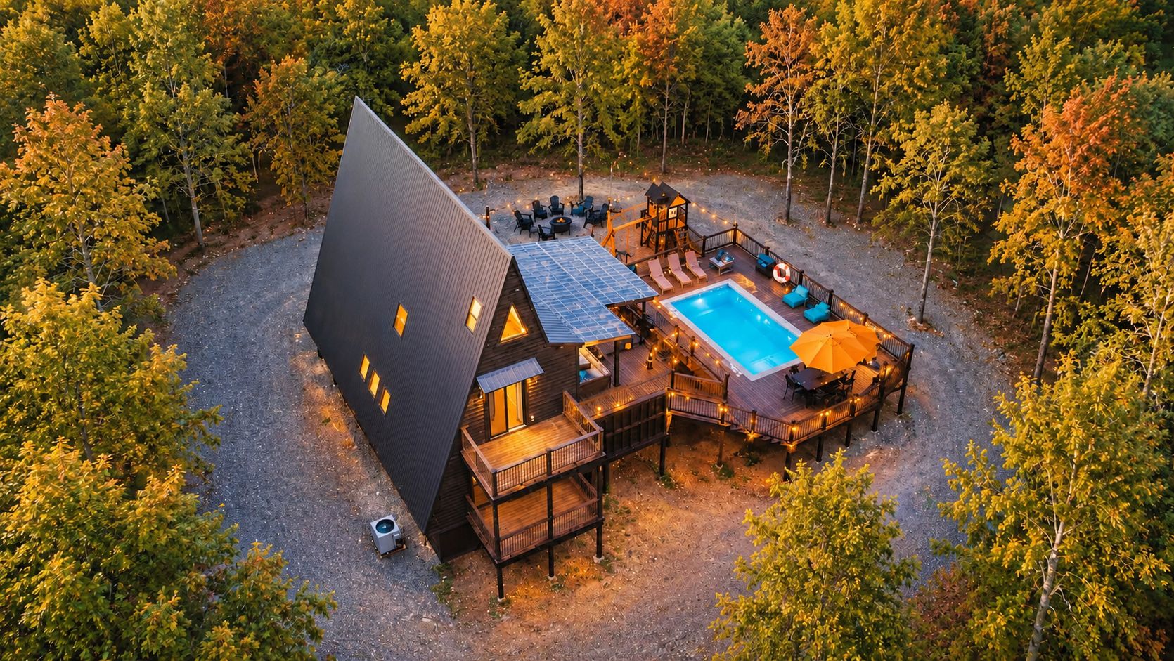 A modern house with a swimming pool, deck, and outdoor seating area surrounded by trees.