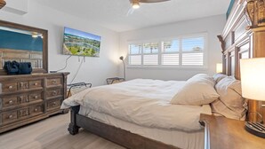 Ein Schlafzimmer mit Bett, Schminktisch und Deckenventilator.