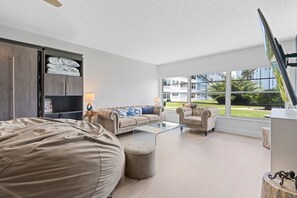 A modern living room with a sofa set, ottoman, and a glass coffee table. - Salty Breeze Escape|Pool|GulfView (St. Pete Beach)