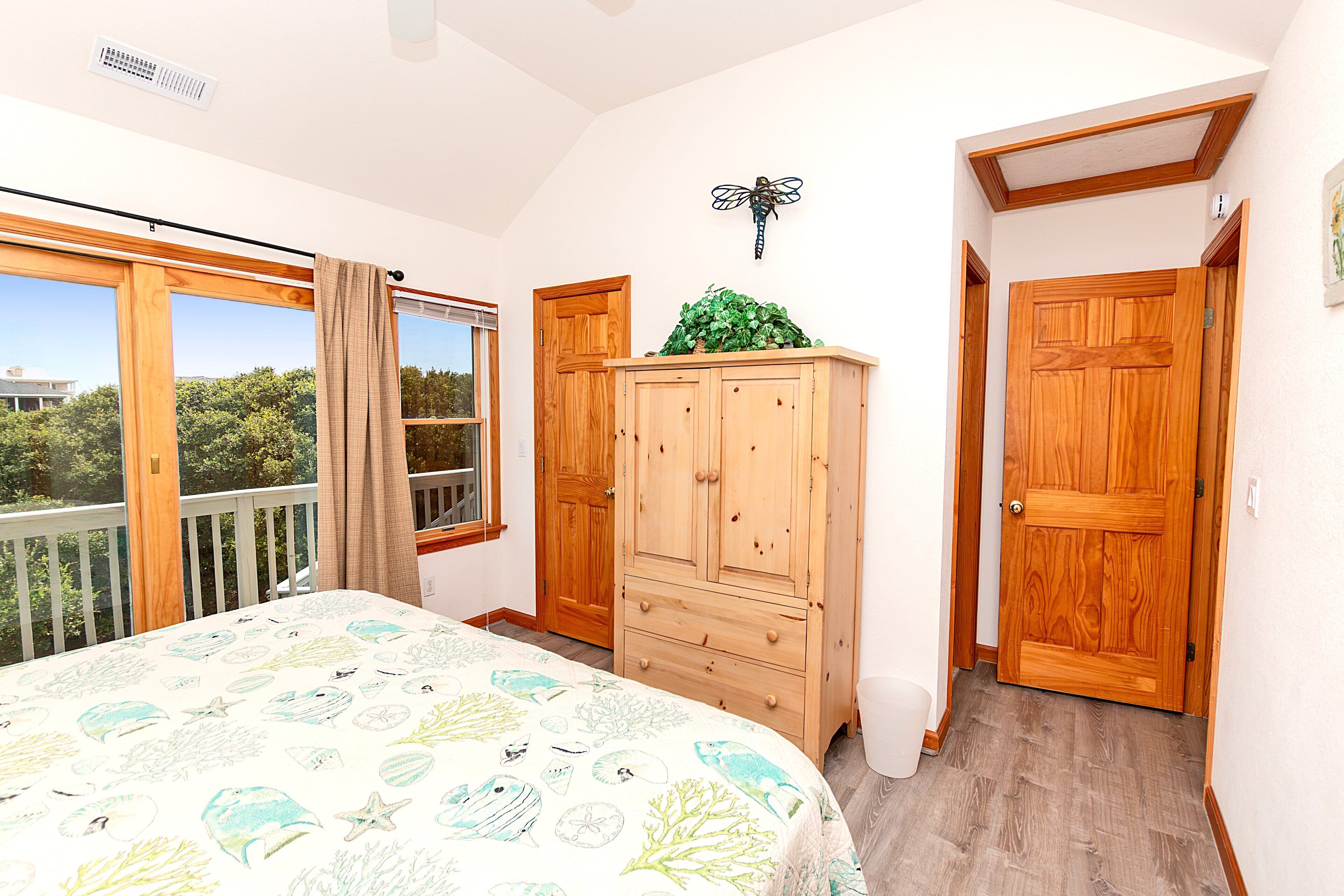 Une chambre à coucher avec un lit, une armoire en bois et une fenêtre avec des rideaux.