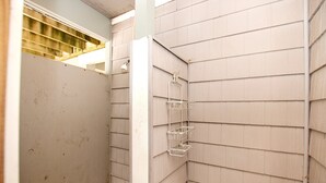 A corner bathroom with a shower, a metal towel rack, and a wooden floor. - Oceanside, close to beach, Priv. Pool, Hot Tub, Dogs Welcome-  WW1033, Driftwood I (Corolla)