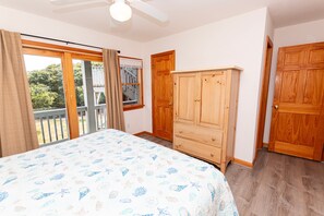 A bedroom with a bed, wooden wardrobe, and a door leading to a balcony. - Oceanside, close to beach, Priv. Pool, Hot Tub, Dogs Welcome-  WW1033, Driftwood I (Corolla)