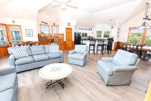 A spacious living area with a large sofa set, a dining table with chairs, and a kitchen area with a refrigerator and microwave. - Oceanside, close to beach, Priv. Pool, Hot Tub, Dogs Welcome-  WW1033, Driftwood I (Corolla)