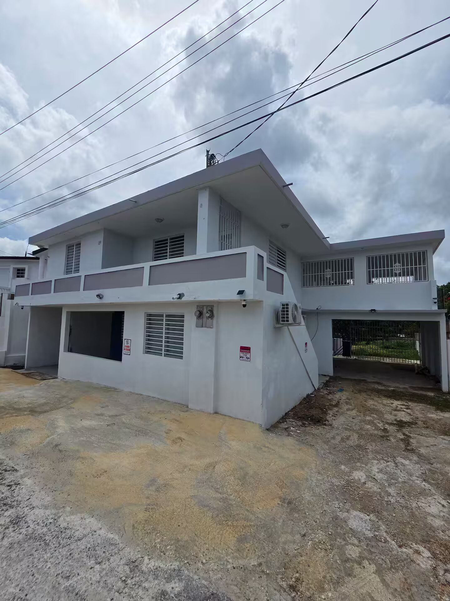A two-story residential building with a flat roof, multiple windows, and a garage.