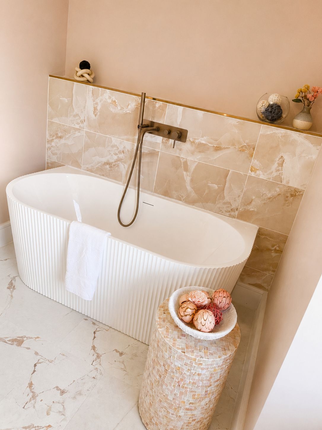 Un bagno con una vasca freestanding, un appendi asciugamani e un cesto decorativo con fiori.