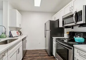 A modern kitchen with white cabinetry, stainless steel appliances, and a black refrigerator. - Entire rental unit in Gainesville, Florida
10 guests4 bedrooms4 beds4 baths (Gainesville)