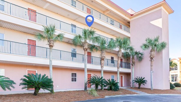 A multi-story hotel with balconies, palm trees, and a blue location marker. - Steps To The Beach-Pet Friendly-Pool-EW303 (Miramar Beach)
