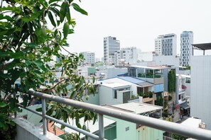 A cityscape with various buildings, including a hotel with a rooftop garden. - Green Apartment near My Khe Beach and Dragon Bridge -R302 (Đà Nẵng)