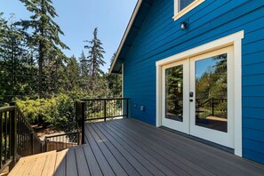 A blue building with a wooden deck and a glass door. - Urban Treehouse on Mt. Scott (Portland)
