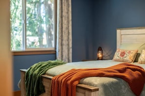 A bedroom with a bed, a window, and a nightstand. - Urban Treehouse on Mt. Scott (Portland)