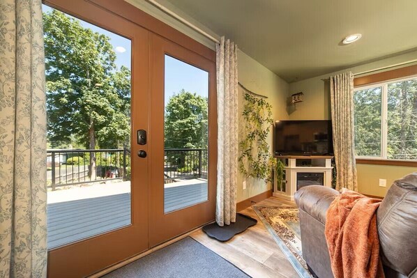 A living room with a large window, a television, and a sofa.