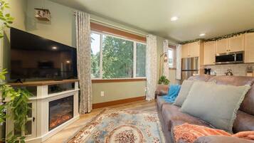 A living room with a fireplace, television, and a large window.