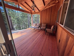 A wooden deck with a table and chairs, overlooking a forest. - Brand New custom built 2 bedroom home in Hiouchi near Stout Grove/Titan Trail (Hiouchi)