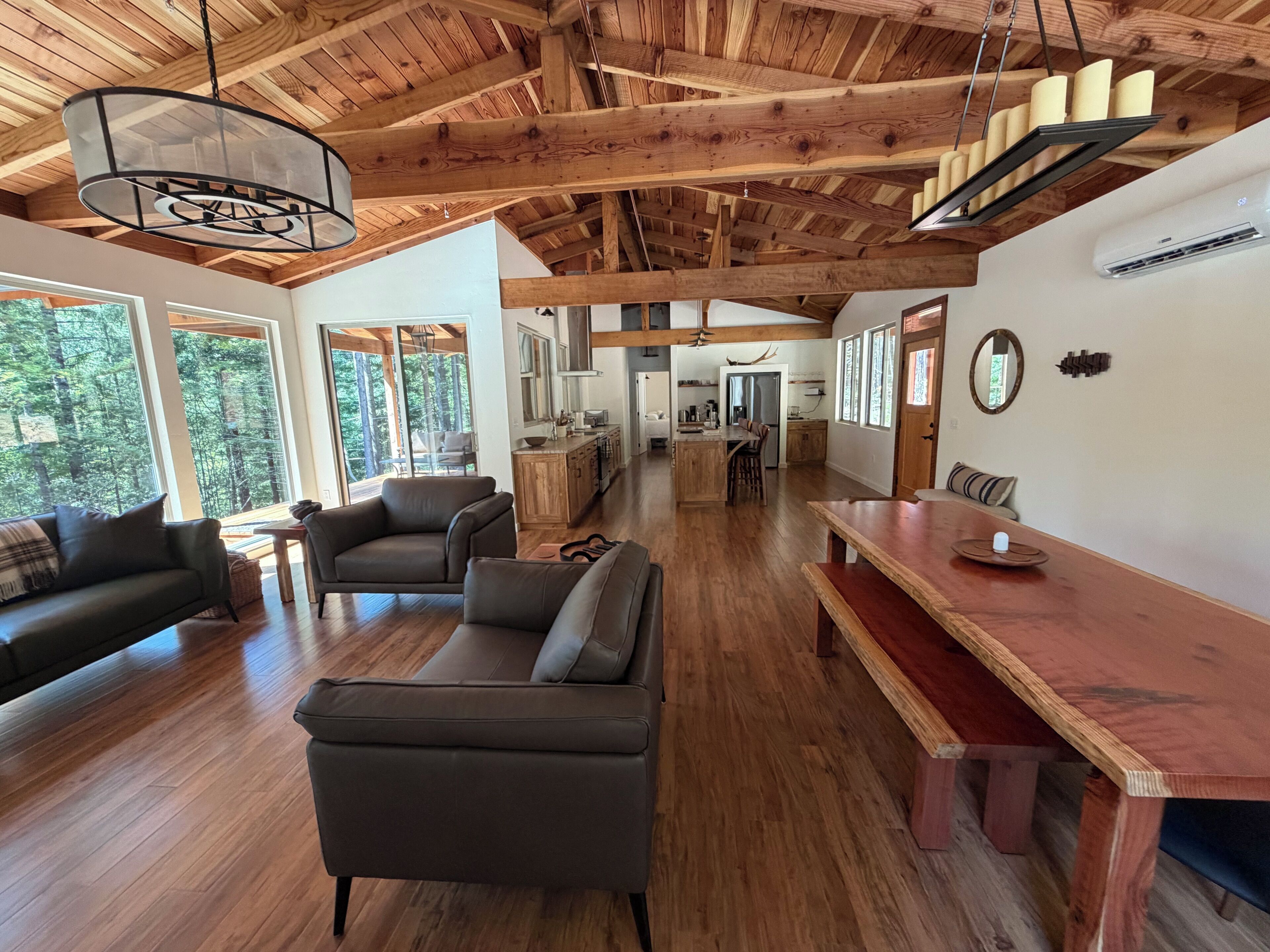 A spacious living area with a wooden ceiling, a dining table, and a sofa.