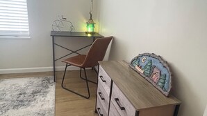 Une pièce comprenant un bureau, une chaise et une commode avec des tiroirs.