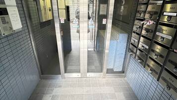 An elevator with glass doors, a tiled floor, and a sign indicating a fire safety area.