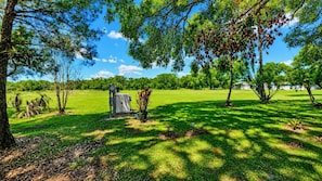 A grassy park with trees, a small utility shed, and a clear blue sky. - Luxury River Ranch RV w/ Pavilion Lot & views! 161 (River Ranch)