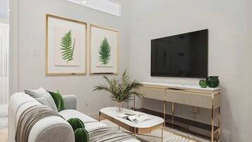 A modern living room with a sofa, coffee table, and a flat-screen TV mounted on the wall.