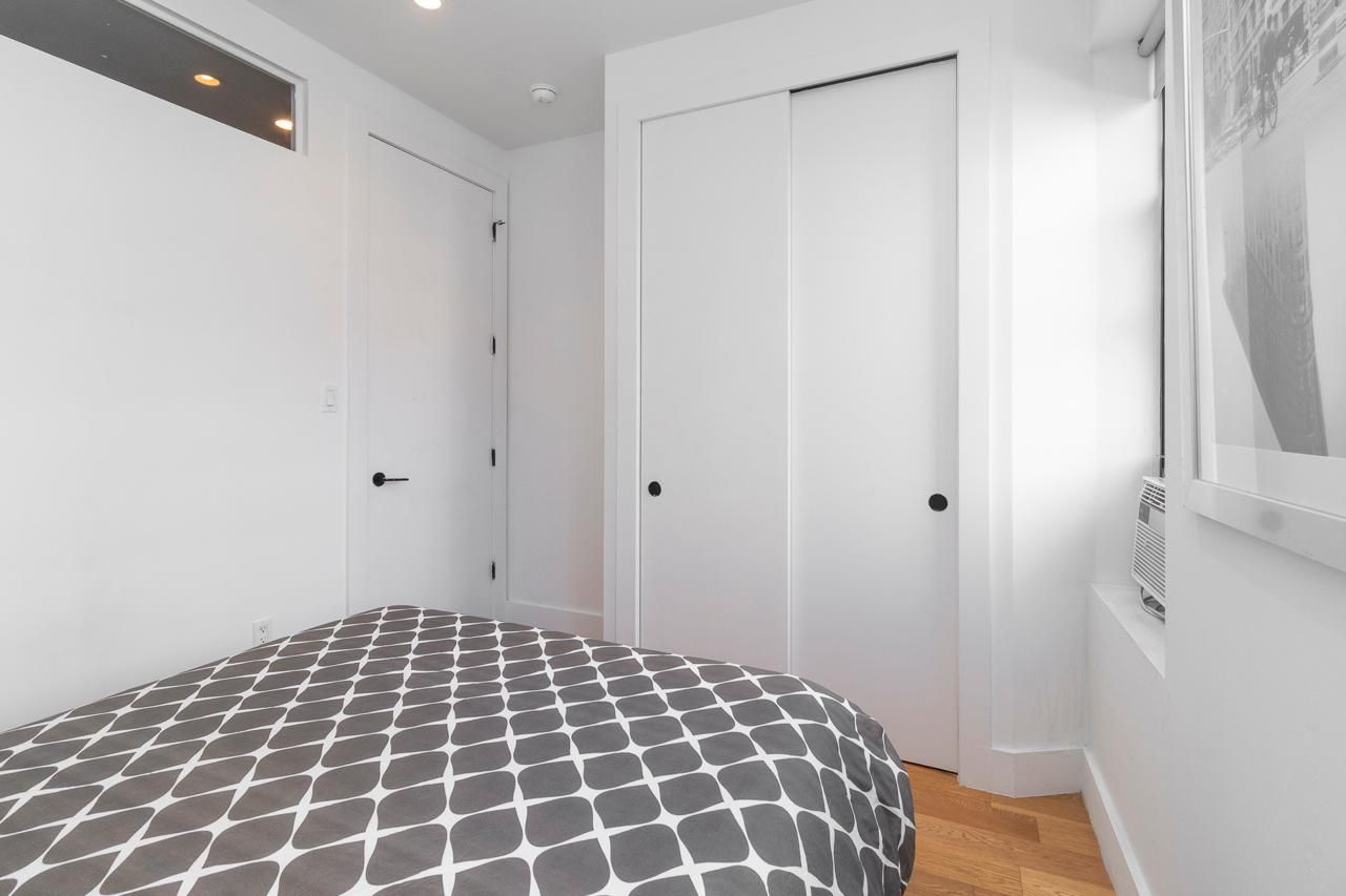 Un dormitorio con cama, dos puertas blancas y un radiador.