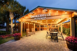 Un ristorante chiamato Smokehouse sul Fiume, con posti a sedere all'aperto e luci decorative.