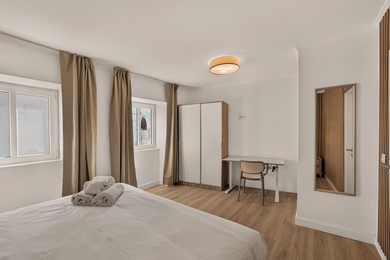 Un dormitorio moderno con cama, escritorio y silla.