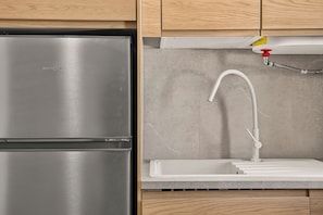 Ein Edelstahl-Kühlschrank und eine Küchenspüle mit Wasserhahn.