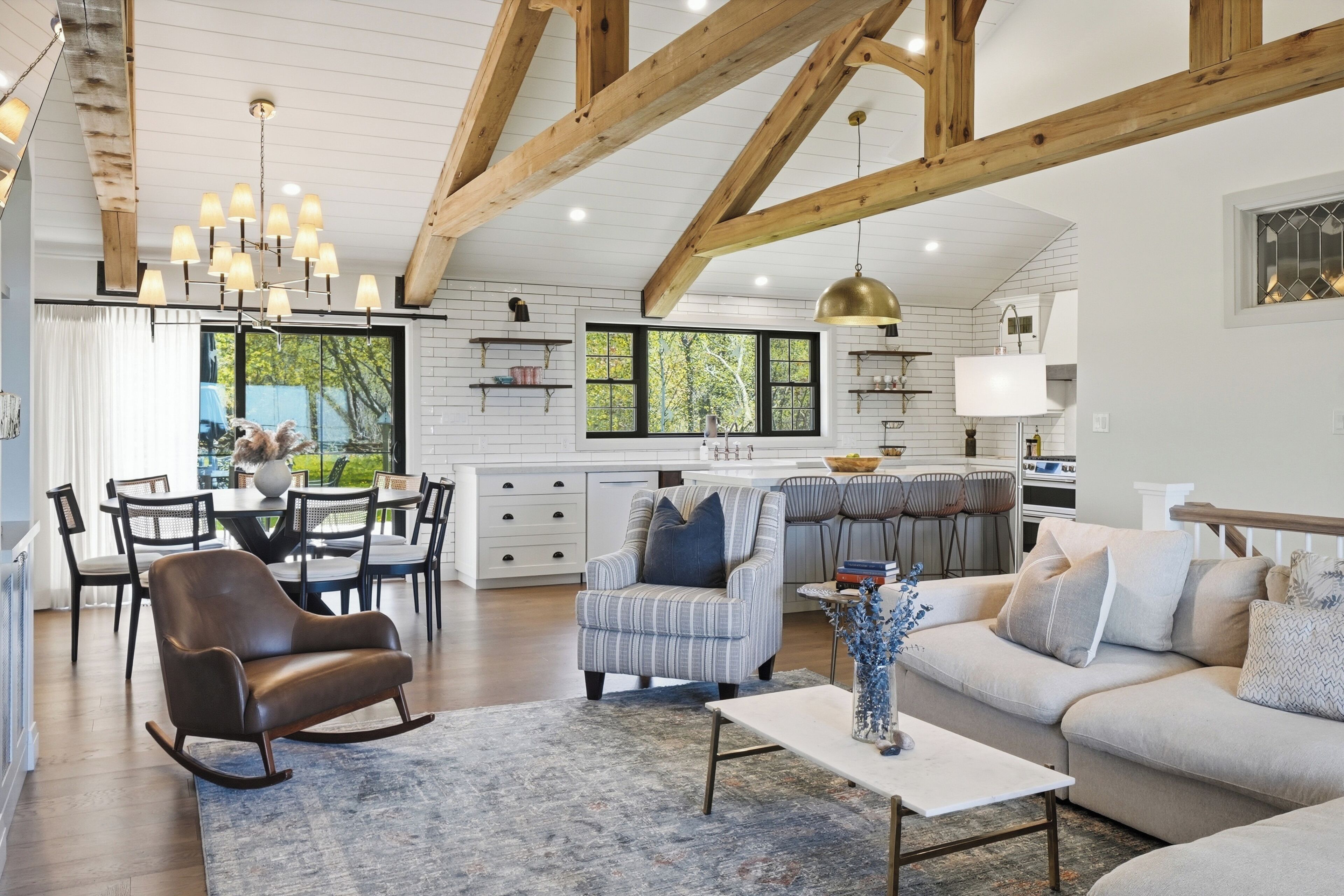 A spacious living area with a dining table, sofas, and a kitchen in the background.