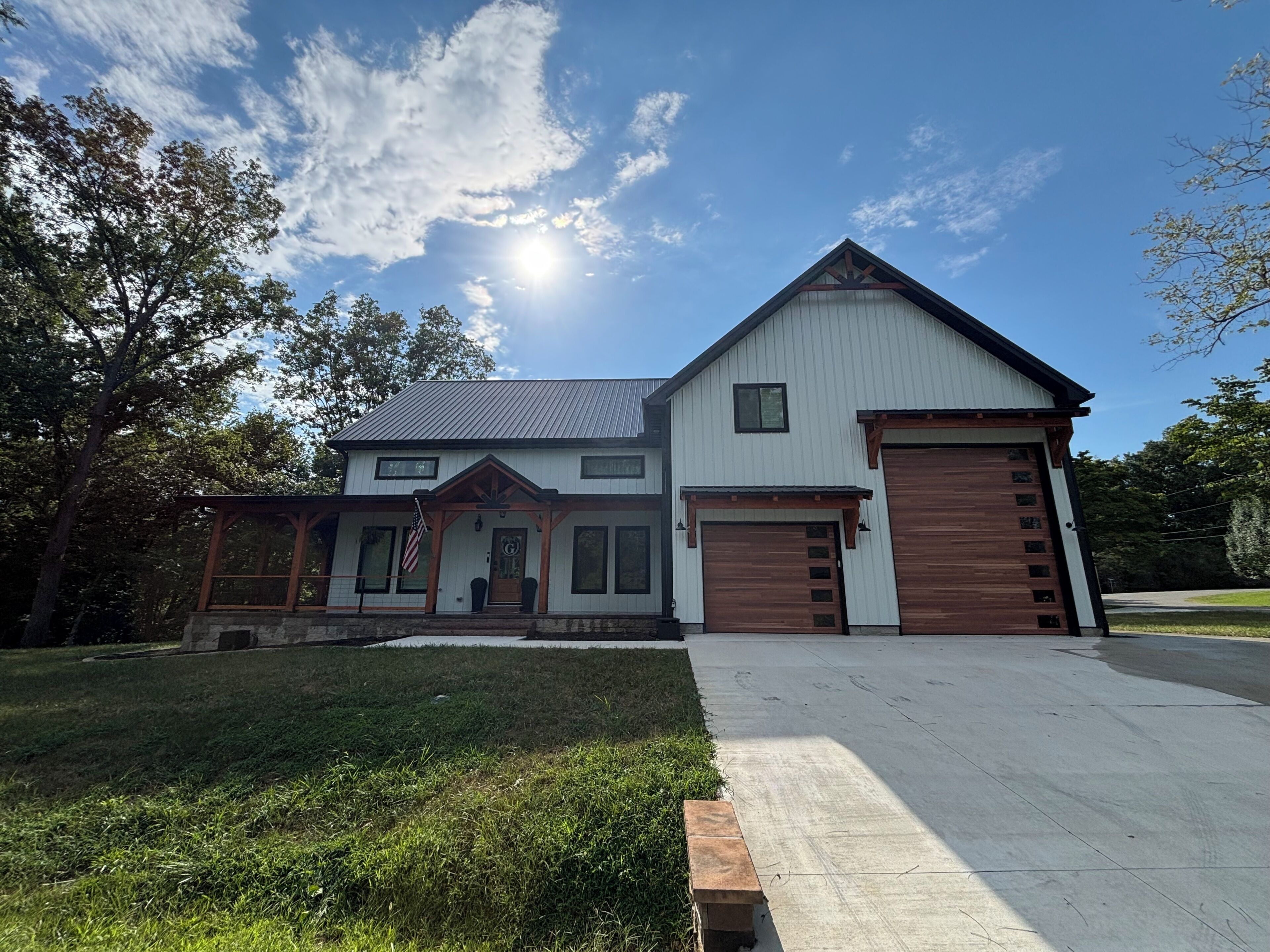 Une maison à deux étages avec un garage, un porche à l’avant et une pelouse bien entretenue.