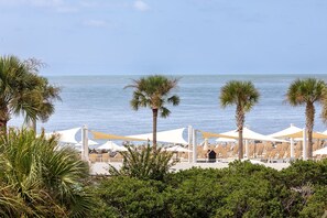 A beachside resort with sun loungers and palm trees. - Oyster Shell Villa by Sandpiper | Near Beach (Seabrook Island)