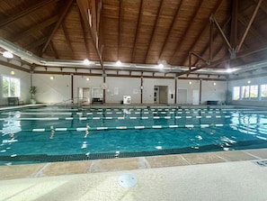 An indoor swimming pool with clear lanes, a wooden ceiling, and a clock on the wall. - Oyster Shell Villa by Sandpiper | Near Beach (Seabrook Island)