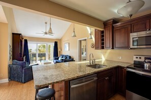 A kitchen with granite countertops, stainless steel appliances, and wooden cabinets. - Oyster Shell Villa by Sandpiper | Near Beach (Seabrook Island)